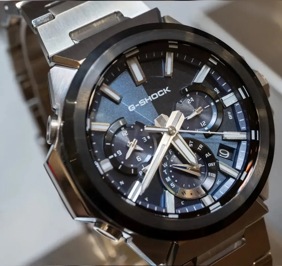 Close-up of the blue-dial Casio G-Shock GST-W1000AD-2A, showing its layered three-subdial layout, luminous markers, silver hands, and black bezel. - Casio's Sleeker G-Steel GST-W1000 Swaps Rugged Bulk for Refined Steel