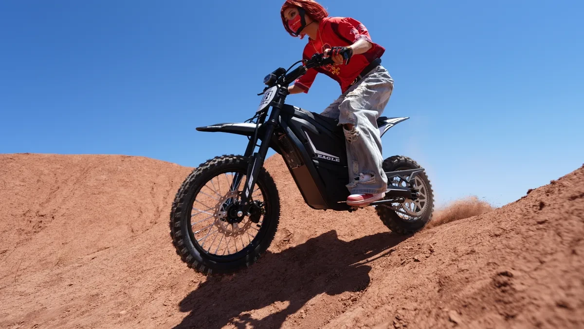 The Engwe Eagle electric dirt bike parked on a dirt trail, showcasing its motocross-style frame and rugged off-road tires.