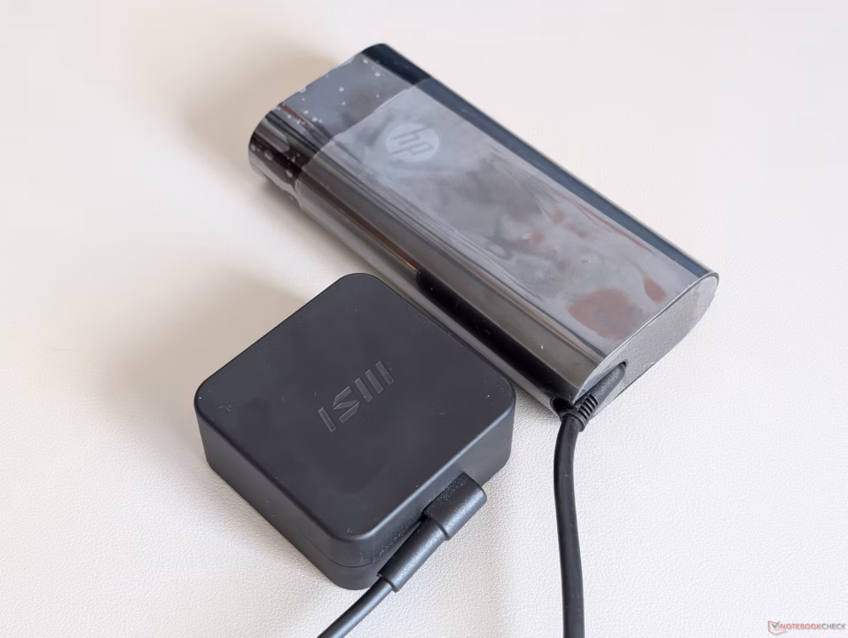MSI Prestige 16 AI+ laptop with 65 W AC adapter showing charging performance